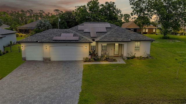 16195 Maya Cir, Punta Gorda, FL 33955 - view of front of property with stucco siding, decorative driveway, an attached garage, solar panels, and roof with shingles