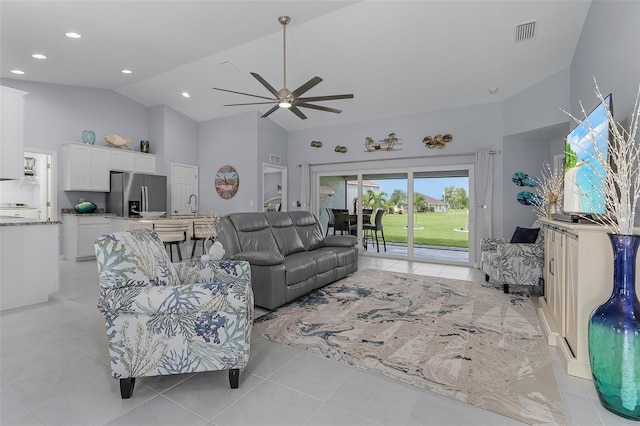 tiled living room featuring ceiling fan and high vaulted ceiling