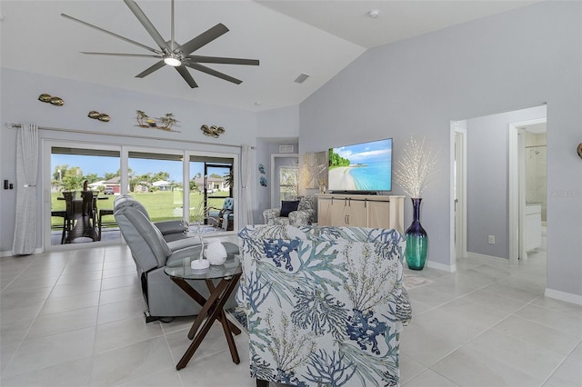 living room with ceiling fan, vaulted ceiling, and light tile patterned floors