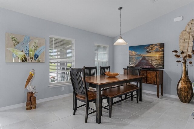 dining room featuring vaulted ceiling and light tile patterned floors