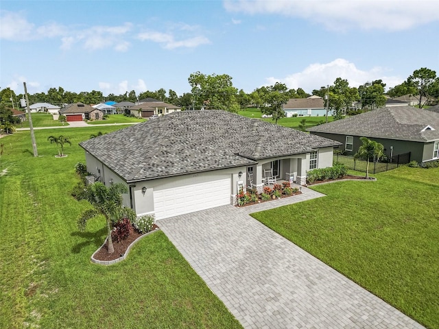 ranch-style home with a garage and a front lawn