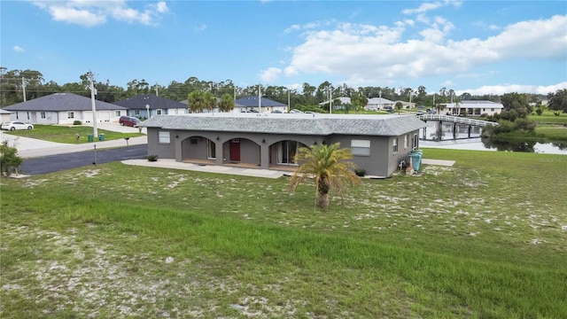 rear view of property featuring a water view and a yard