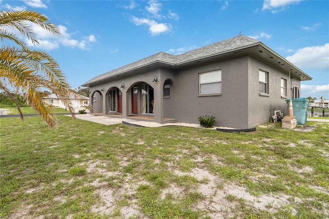 back of property featuring a patio area and a lawn