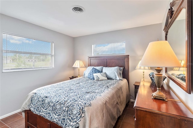 bedroom featuring dark tile patterned flooring and multiple windows