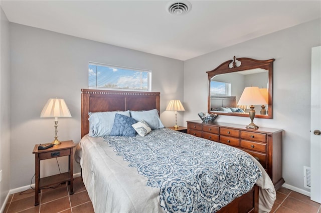 bedroom featuring dark tile patterned floors and multiple windows