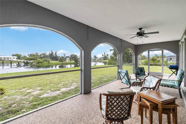 sunroom with a water view, a healthy amount of sunlight, and ceiling fan