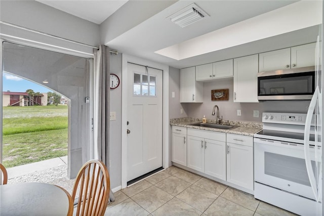 kitchen with sink, white cabinets, white electric range, and light tile patterned flooring