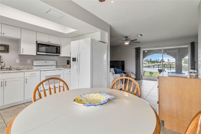 tiled dining area with ceiling fan and sink