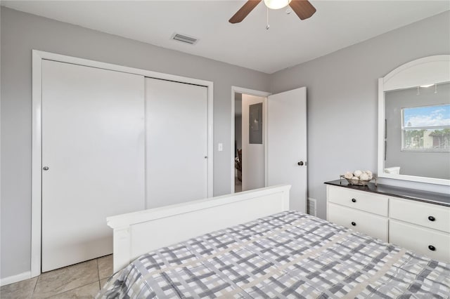 tiled bedroom featuring ceiling fan and a closet