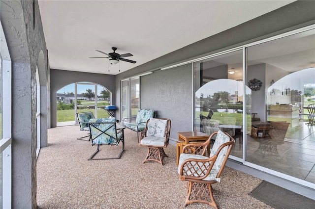 sunroom / solarium featuring ceiling fan