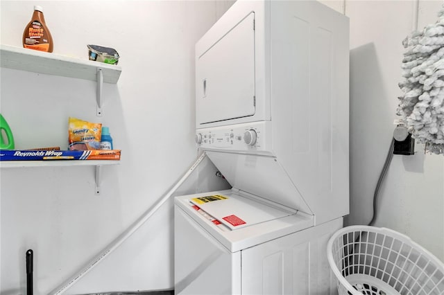 clothes washing area with stacked washer and clothes dryer