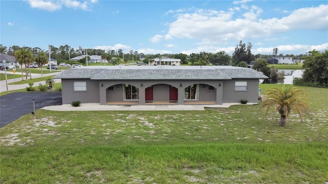 back of property with a water view and a yard