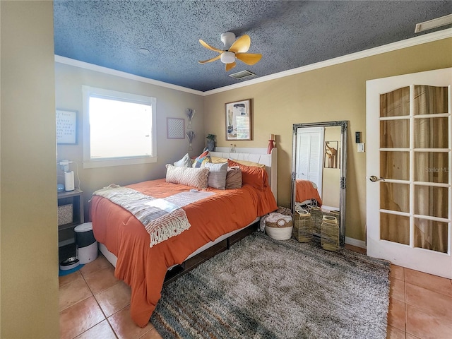 tiled bedroom with ornamental molding, a textured ceiling, and ceiling fan