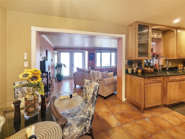 dining space with light tile patterned floors, ornamental molding, a textured ceiling, and french doors