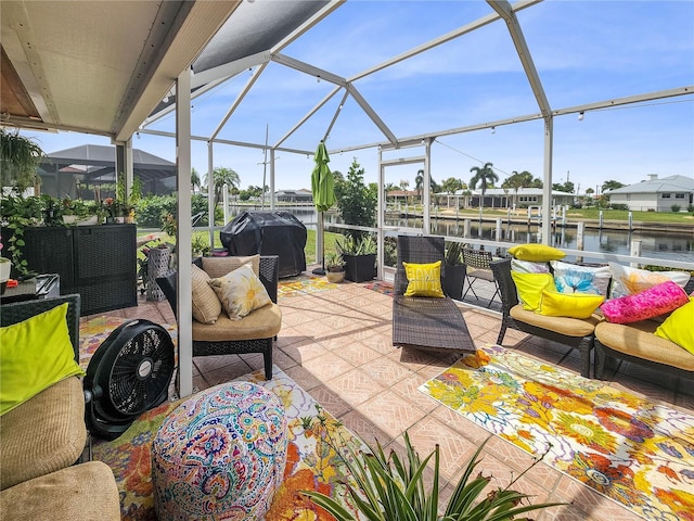 view of patio / terrace featuring glass enclosure, a water view, a grill, and an outdoor living space