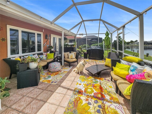 view of patio / terrace with area for grilling, glass enclosure, outdoor lounge area, and a water view