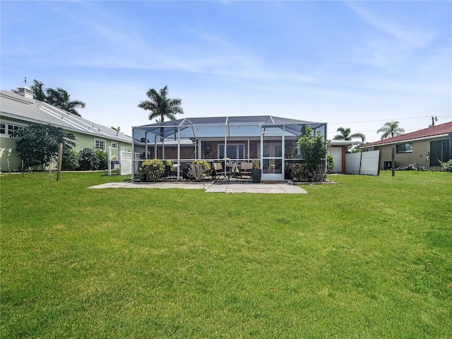 rear view of house with a patio, a yard, and a lanai