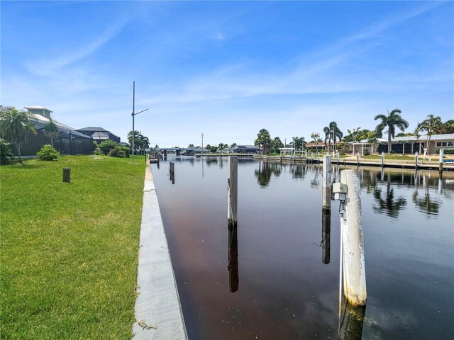 dock area with a water view and a lawn