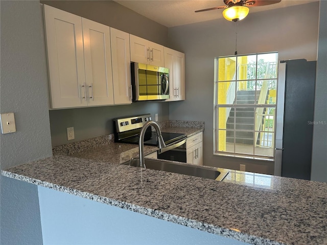 kitchen with white cabinetry, light stone countertops, and stainless steel appliances