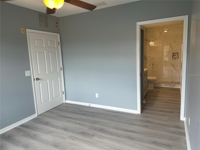 unfurnished bedroom featuring ceiling fan, light hardwood / wood-style floors, and ensuite bath