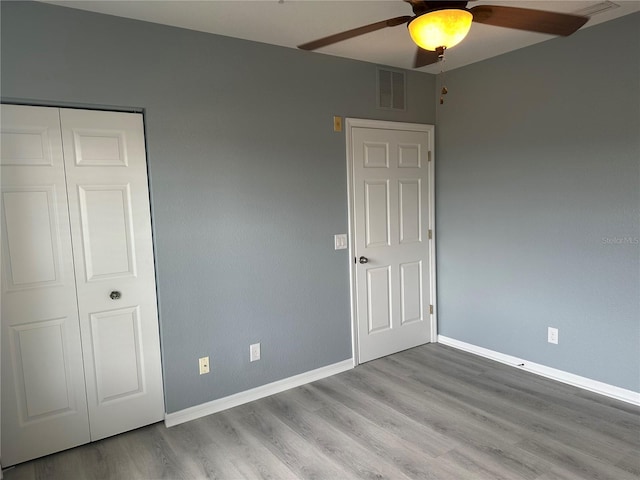 unfurnished bedroom featuring a closet, ceiling fan, and light wood-type flooring