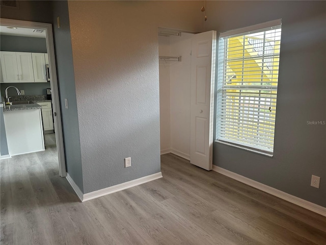 spare room featuring sink and light hardwood / wood-style flooring