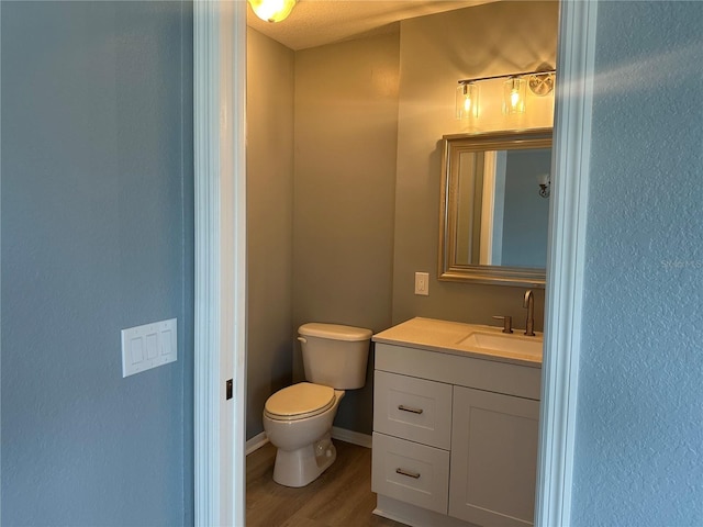 bathroom featuring vanity, wood-type flooring, and toilet