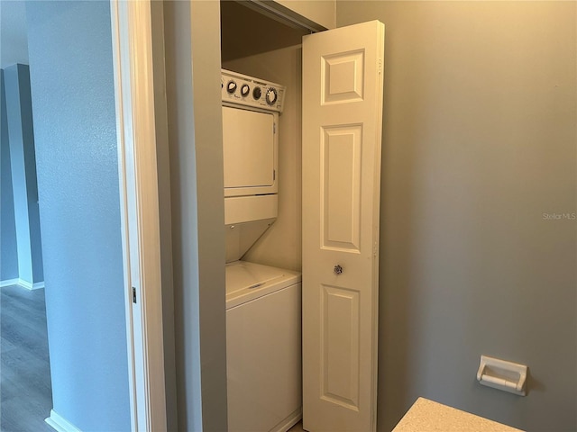 laundry room featuring stacked washer / drying machine