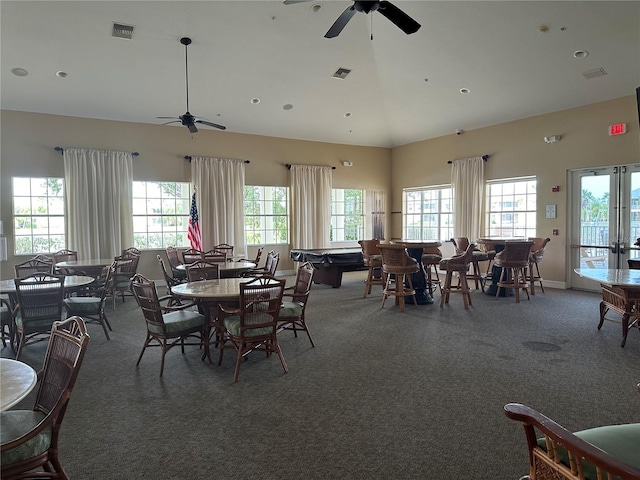 carpeted dining space with high vaulted ceiling, french doors, and ceiling fan