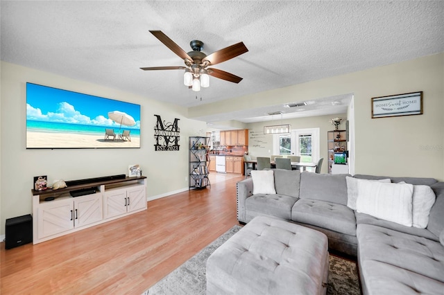 living room with ceiling fan, wood-type flooring, and a textured ceiling