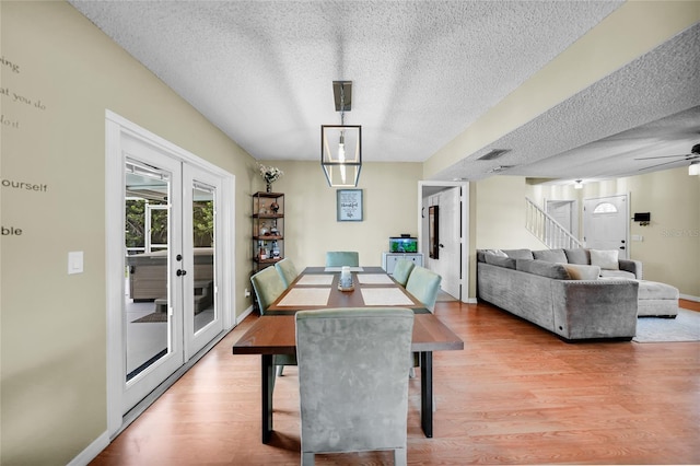 dining room with french doors, ceiling fan, light hardwood / wood-style flooring, and a textured ceiling