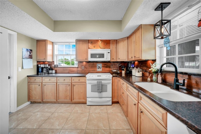 kitchen featuring tasteful backsplash, white appliances, decorative light fixtures, and sink