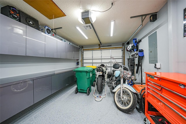 garage with a garage door opener and electric panel