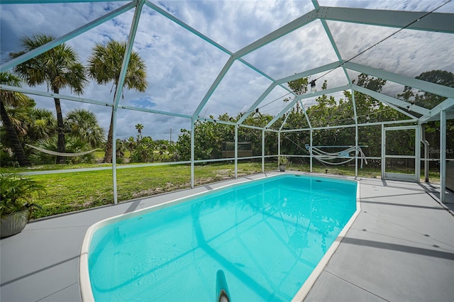 view of swimming pool featuring a patio, a lanai, and a lawn