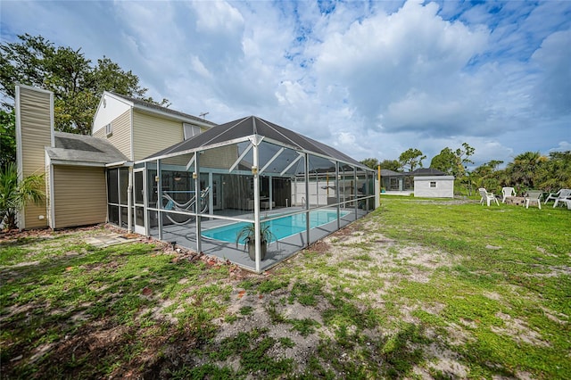 view of swimming pool with a patio, a lanai, and a lawn