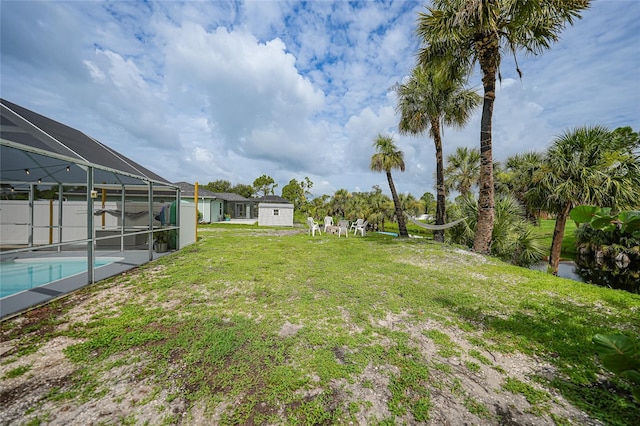 view of yard with a fenced in pool and glass enclosure