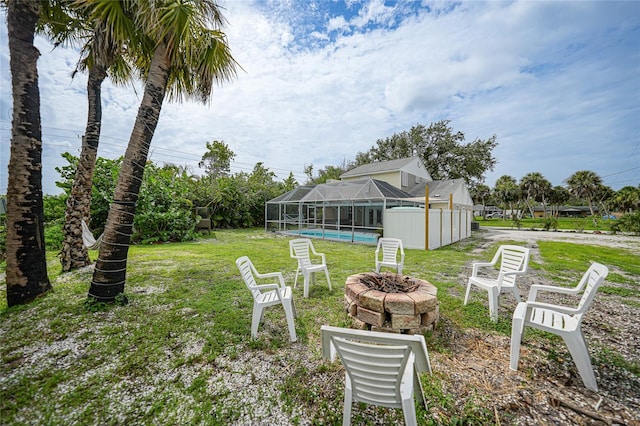 view of yard featuring glass enclosure and an outdoor fire pit