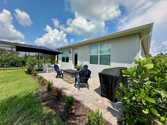 back of property with an outdoor fire pit, a yard, and a patio area