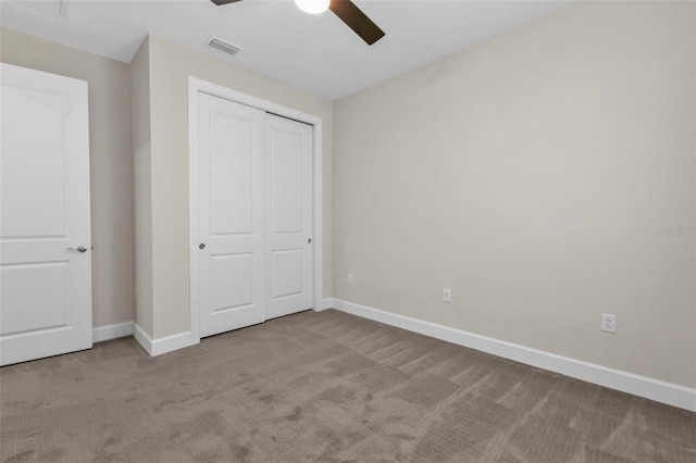 unfurnished bedroom featuring light colored carpet, a closet, and ceiling fan