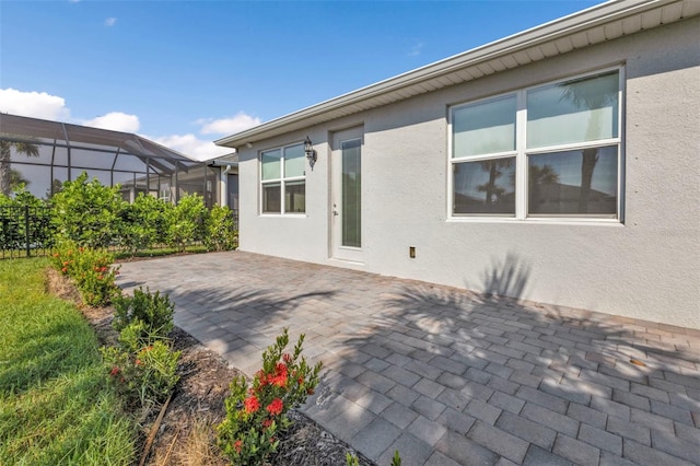 back of house with a patio and glass enclosure