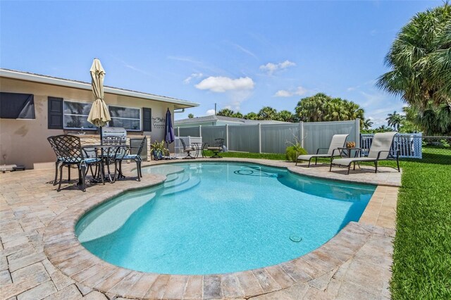 view of pool with a patio and a grill