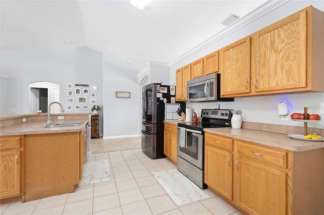 kitchen with sink, vaulted ceiling, light tile patterned floors, ornamental molding, and stainless steel appliances