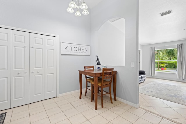 tiled dining room featuring an inviting chandelier