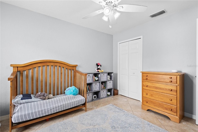 tiled bedroom featuring ceiling fan and a closet