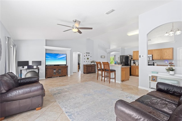 tiled living room featuring ceiling fan with notable chandelier and vaulted ceiling