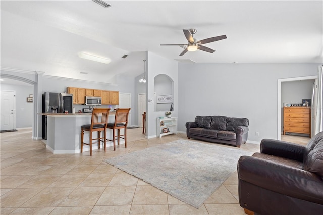 tiled living room featuring ceiling fan and vaulted ceiling