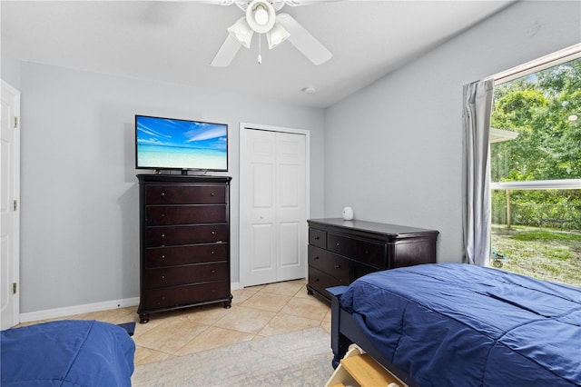 tiled bedroom with ceiling fan and a closet