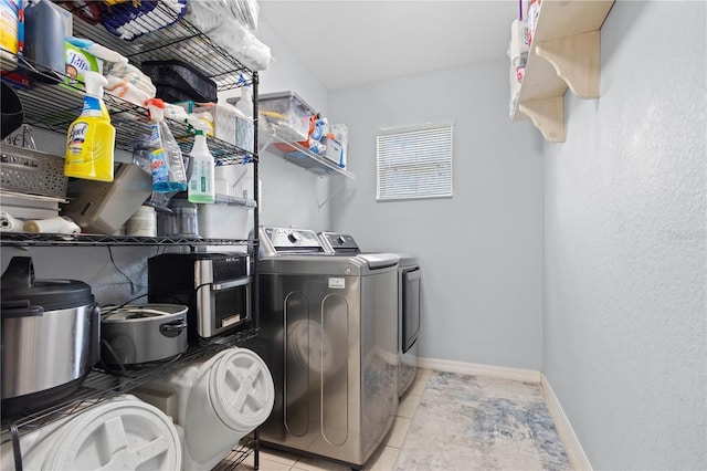 laundry area featuring light tile patterned floors and washing machine and clothes dryer