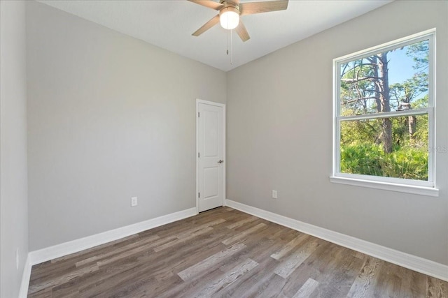 unfurnished room with a ceiling fan, baseboards, and wood finished floors