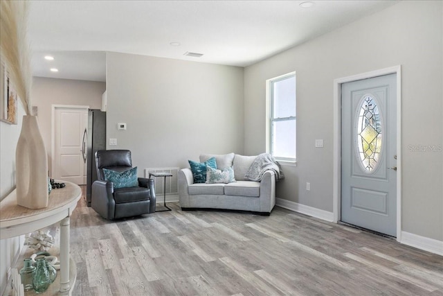 living area with recessed lighting, baseboards, and light wood finished floors